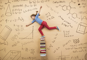 Cute girl learning playfully in frot of a big blackboard