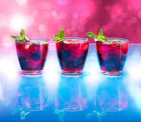 Raspberry and blackberry cocktail with mint garnish. Studio shot