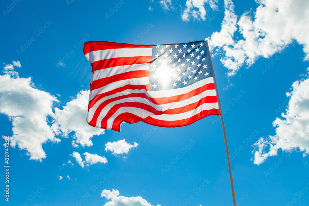 Sticker us flag with cumulus clouds and blue sky on background