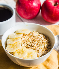 oatmeal with bananas, apples and a cup of coffee