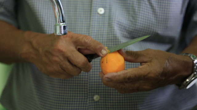 Close up of man's hand chopping an Marian plum