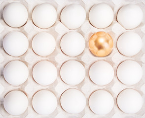 gold Easter egg between many white eggs