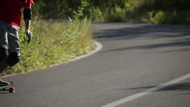 Downhill skateboarder in action on a asphalt road