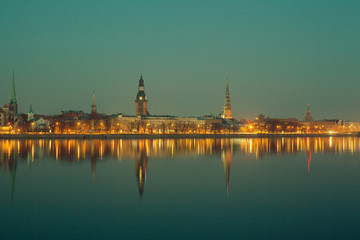 Fototapeta premium Night view of Riga with reflection in river, with retro colors