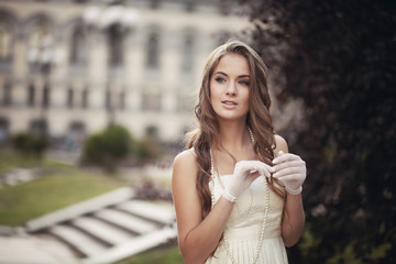 young beautiful girl in a white dress and white gloves