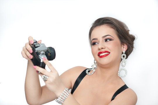 Beautiful young girl with make-up taking photos of herself