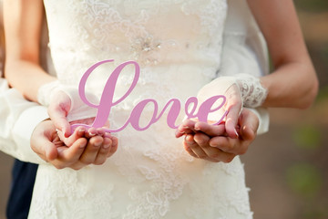 Bride and groom with wooden words Love