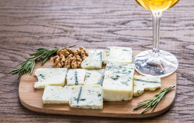 Roquefort with glass of white wine on the wooden board