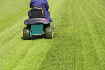 Mowing the grass motor lawn mower on a football field