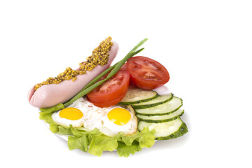 two quail eggs fried with vegetables and sausage with mustard