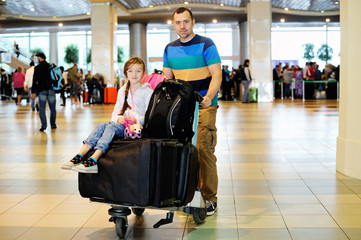  Father and daughter with the luggage at airport