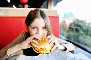Cute little  girl eating a hamburger