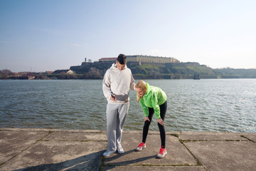 Two young runners taking a break while jogging by the river