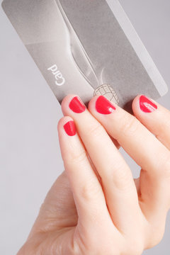 Closeup of a woman's hand holding up a credit card.