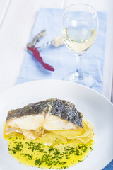 Bacalao asado con patatas y vino blanco para acompañar