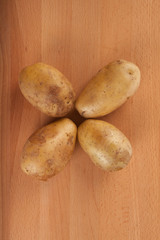 Four  potatoes on wooden table