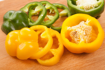 Cut yellow and green bell peppers on cutting board