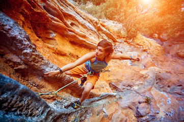 Rock climber climbing up a cliff - obrazy, fototapety, plakaty