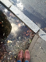 person standing next to puddle after rain 