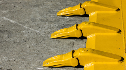 Big yellow bucket scoop on rough concrete ground. © Paweł Michałowski