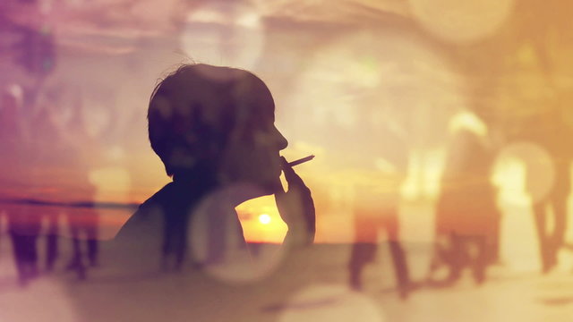 Silhouette of a Woman Smoking Cigarette in Sunset