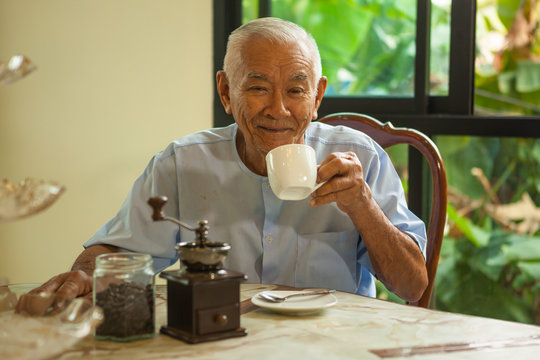 Asian Senior Man With Vintage Coffee Grinder