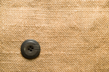 One big vintage button on  old cloth