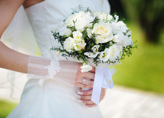 Obraz na płótnie Canvas Bride holding a beautiful white wedding bouquet