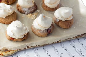 Shortbread cookies with peanut and meringues on cooking paper an - obrazy, fototapety, plakaty