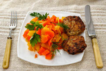 Turnip stew with carrots and cutlets on a plate