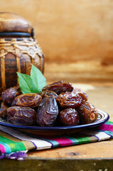 Dry dates on oriental ceramic plate with empty space