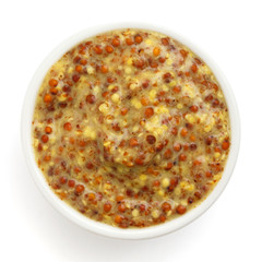 French dijon mustard in round dish from above on white.