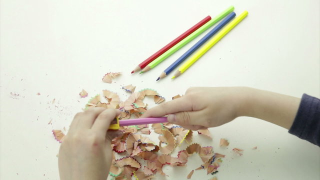 Hands sharpening a colorful pencil crayon