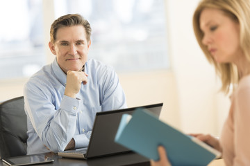 Confident Businessman With Colleague In Office