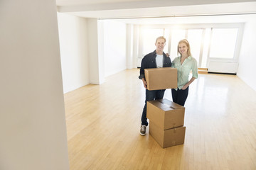 Fototapeta na wymiar Happy Mature Couple With Cardboard Boxes In New House