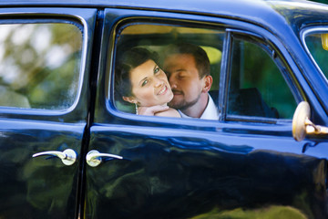 A wedding couple in old car