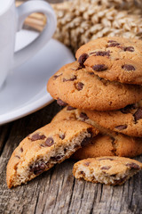 Cup of coffee with cookies and wheat on a wooden table.