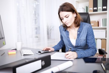Hardworking businesswoman sitting writing a report