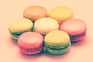 Sweet colorful macaroons against pink background. Top view