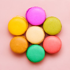 Sweet colorful macaroons against pink background. Top view