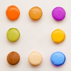 Sweet colorful macaroons against pink background. Top view