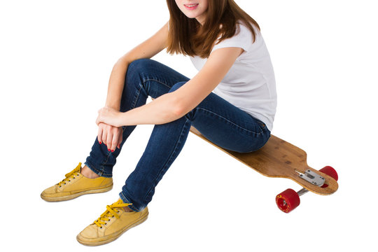 Young woman sitting on a skateboard