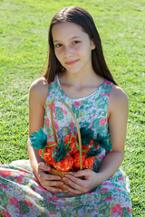 Smiling cute teen girl with basket with carrot of sweet popcorn