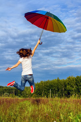 Woman jumping with colorful umbrella