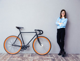 Fototapeta na wymiar Happy businesswoman standing near bicycle