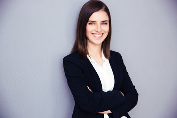 Happy young businesswoman with arms folded