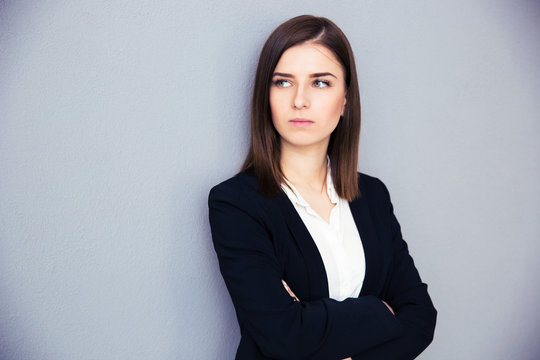 Young serious businesswoman with arms folded