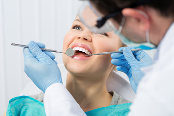 Regular dentist visit. Caries cure. Young woman visiting dentist - obrazy, fototapety, plakaty