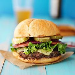 gourmet hamburger on colorful rustic table;