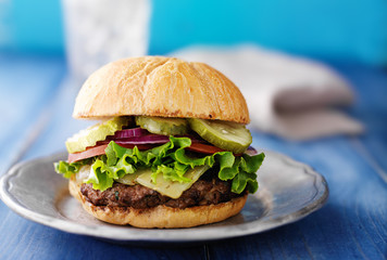 gourmet cheeseburger on colorful blue rustic table top